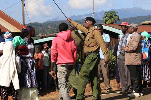 An Administration Police officer orders Munyange AIPCA church members off the premises after two rival groups clashed on April 16, 2017 during the Easter Sunday church service. The church has been wracked by chaos for the past one year.