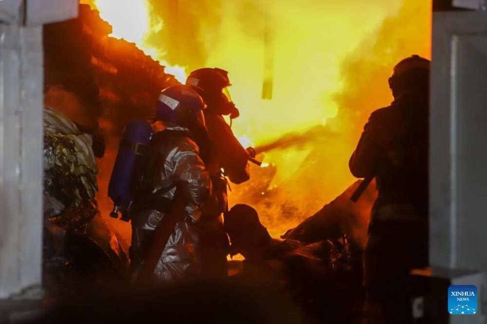 Firefighters work at the site of a fire resulting from a gas explosion in the Embakasi neighborhood in Nairobi, Kenya, Feb. 2, 2024. At least two people were killed and 222 others injured in an inferno resulting from a gas explosion in the capital of Kenya here, an official confirmed on Friday morning. Government Spokesman Isaac Mwaura said the fire, which started at around 11:30 p.m. Thursday local time (2030 GMT), was caused by a truck loaded with gas cylinders that exploded, igniting a huge fireball that spread to a warehouse and a neighborhood nearby. (Photo by Joy Nabukewa/Xinhua)