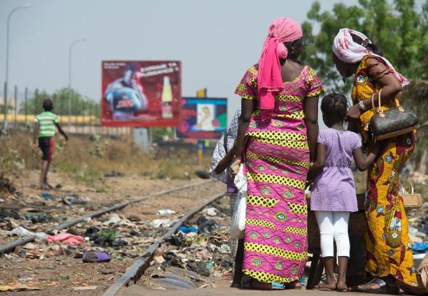 Malian women walk on March 6, 2013, at a street market near railroad tracks in the Malian capital Bamako
