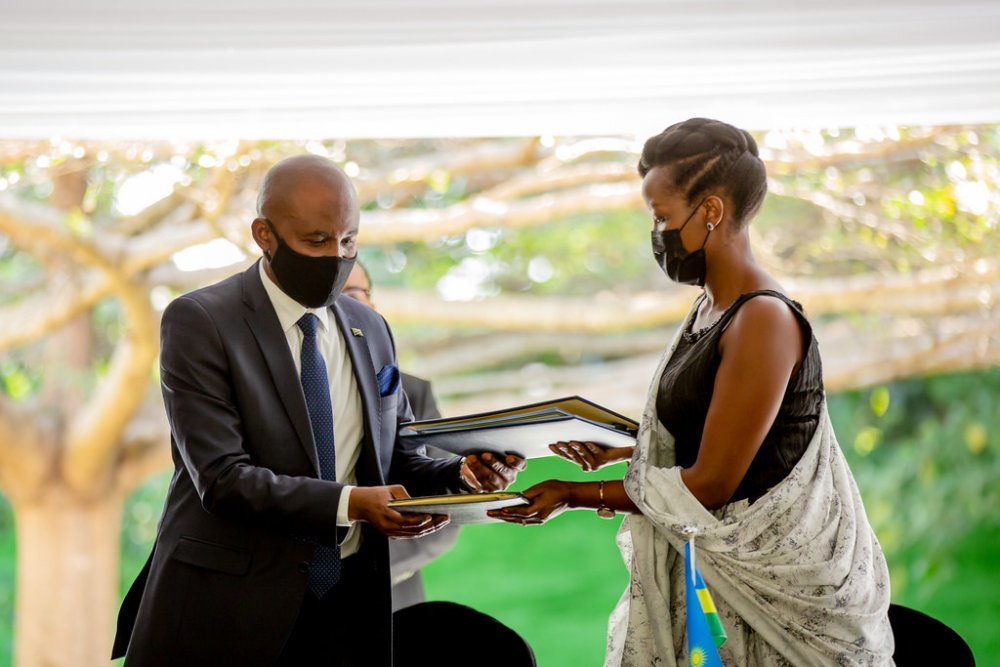 The Minister of ICT, Paula Ingabire and her counterpart of Tanzania, Faustin Ndungulile exchanging documents after signing agreements in the field of communication and ICT.