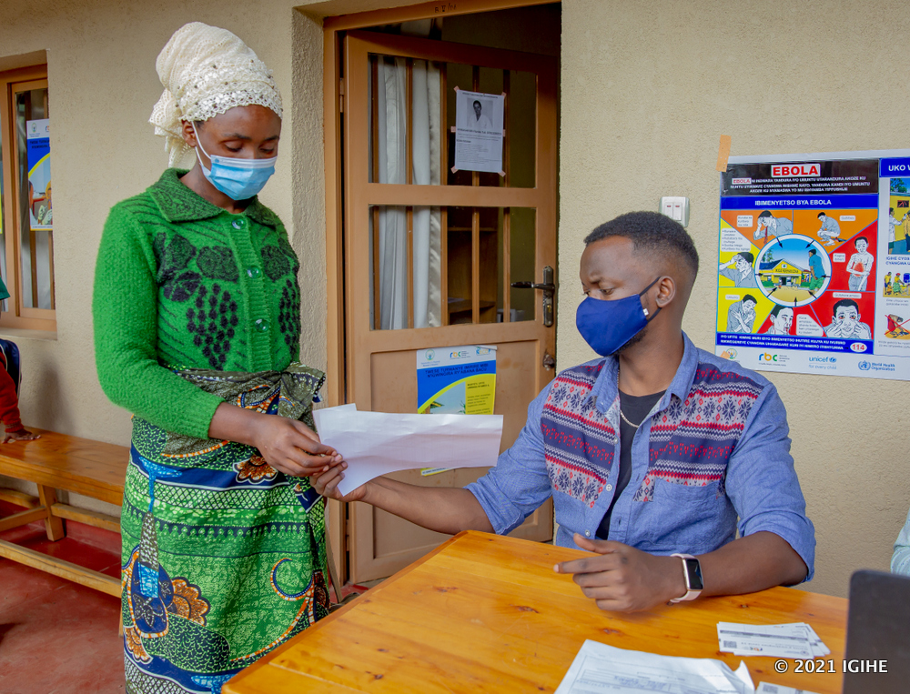 Peace Jolis helping residents to fill vaccination forms. 