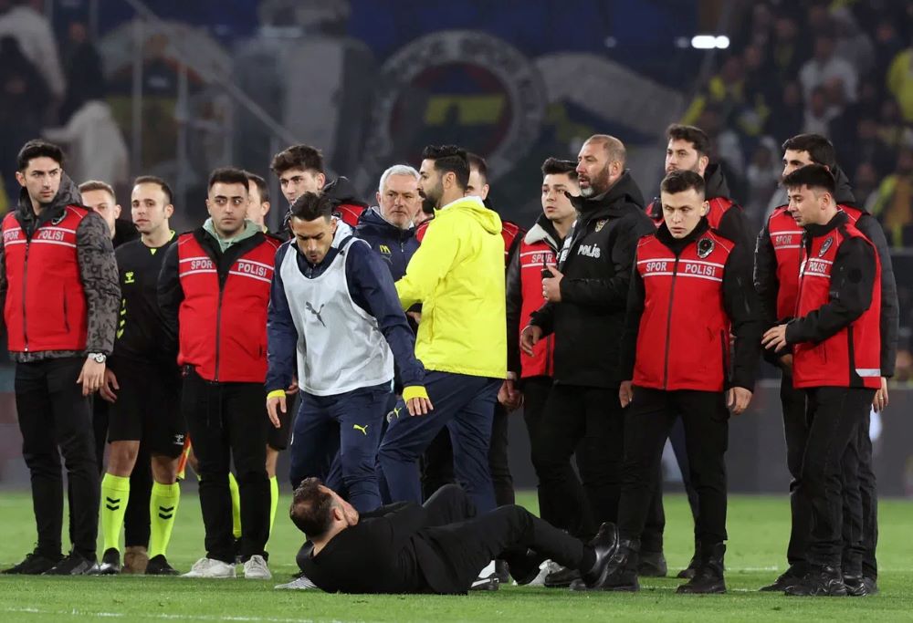 Galatasaray manager Okan Buruk falls to the ground after getting his nose pinched by Fenerbahçe manager José Mourinho on Wednesday in Istanbul, Turkey.