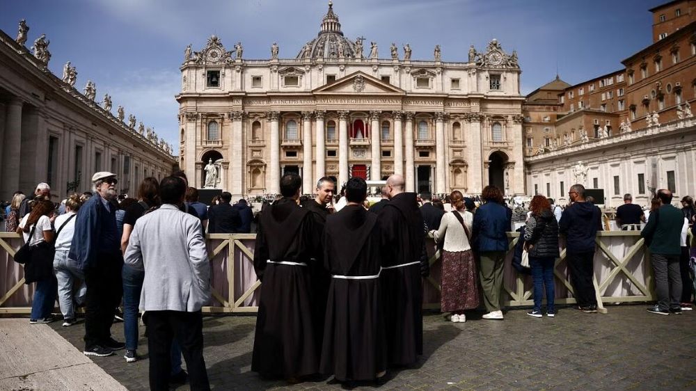 Clergy members stand in St. Peter's Square, after the death of Pope Francis was announced by the Vatican in a video statement, at the Vatican, April 21, 2025.