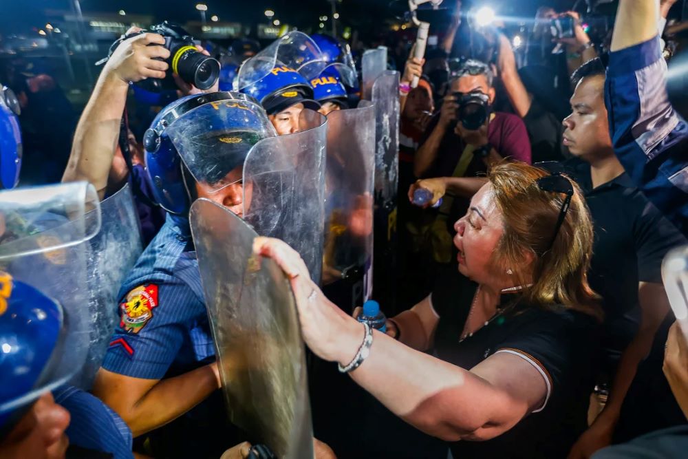 A supporter of Duterte confronts riot police officers outside the Villamor Airbase.