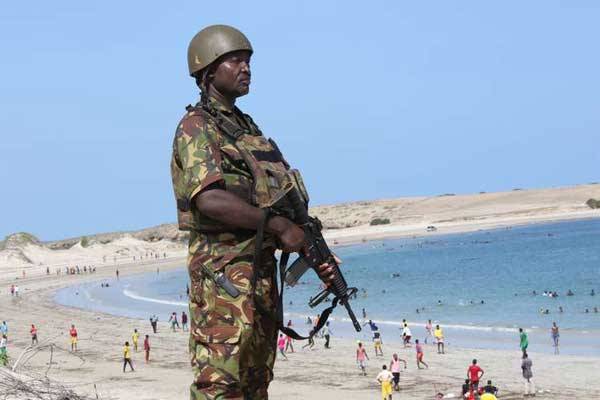 A Kenya Defence Forces soldier on guard as Somali residents swim in the Indian Ocean in Kismayu on November 20, 2015. The US government has approved the sale of weapons worth Sh43.5 billion to the Kenyan military to boost the fight against Al-Shabaab.