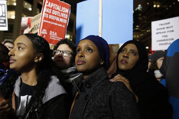 Ayla Ali and her Somali refugee family members, cousin Ryan Adem and aunt Maryan Farah, listen to speakers at a rally for immigrants and refugees in Seattle, Washington on January 29, 2017.