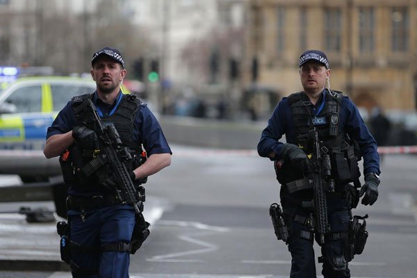 Armed British police officers patrol outside the Houses of Parliament in Westminster, central London on March 22, 2017 following a terror attack.