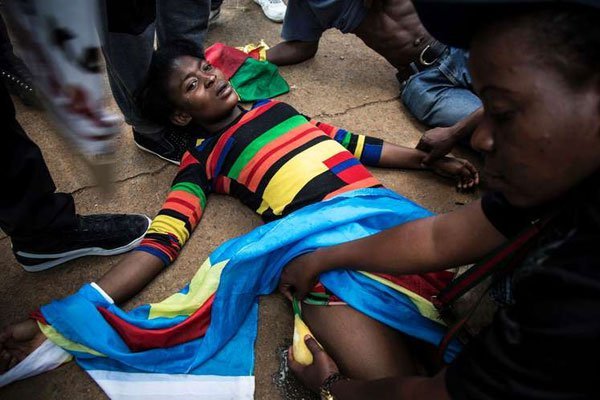 A Congolese protester lies on the ground after police opened fire with rubber bullets whilst they protest outside the Democratic Republic of the Congo's Embassy in defiance of their President, Joseph Kabila on December 20, 2016 in Pretoria.