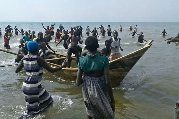 Survivors of a boat accident come back ashore on Lake Albert, on December 26, 2016 in Buliisa, after at least 30 Ugandan members of a village football team and their fans drowned when their boat capsized on Lake Albert during a party.