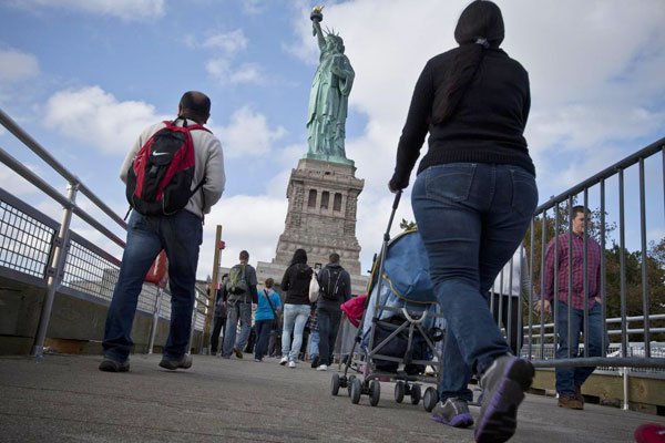Tourists arrive to visit the Statue of Liberty on October 13, 2013 in New York City. Nigeria on March 06, 2017 advised its citizens against all but essential travel to the United States.