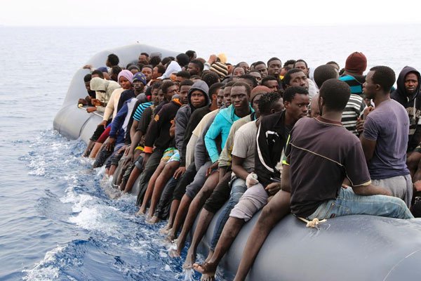 Migrants wait to be rescued from a sinking dingey off the Libyan coast on March 20, 2017, as they attempted to cross from the Mediterranean to Europe.