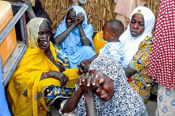 Nigerian women mourn near the site where four female suicide bombers blew themselves up near a bus station in Maiduguri, northeastern Nigeria on March 15, 2017 killing two people.