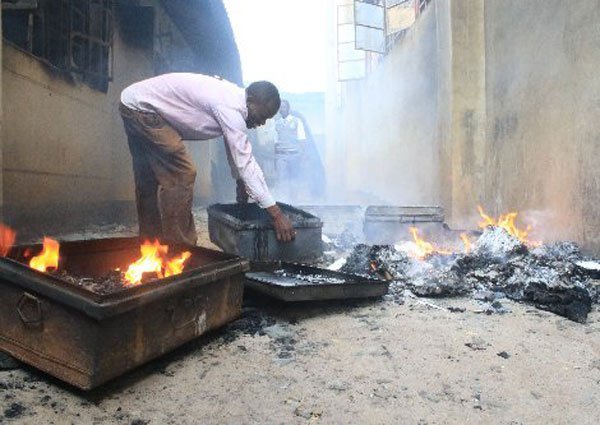 A parent tries to salvage the remains of his son's box at Itierio Boys High School in Kisii County after seven dormitories were set a blaze on June 26, 2016. Before the matchbox was struck to set alight the first dormitory, the students also disconnected electricity supply to the school.