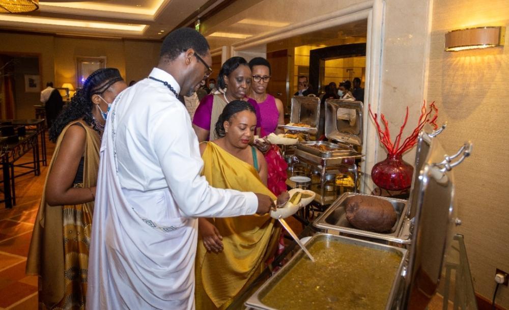 Amb. Hategeka serving traditional food to Rwandans during the celebration of Umuganura. 