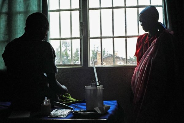A 13-year-old Burundian girl (L), raped by her employer at knifepoint, talks about it in front of her mother as she is helped to recover at SWAA, a gender-based anti-violence centre