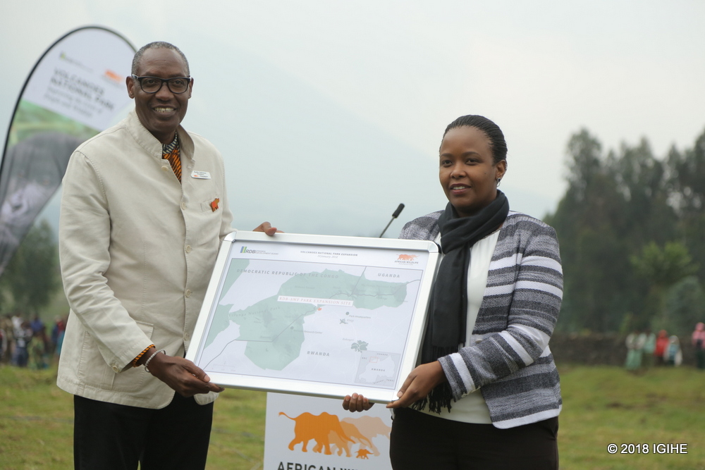 RDB CEO Clare Akamanzi receives land certificate from AWF President Kaddu Sebunya