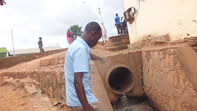 Nyamirambo resident watching a water trench where street kids hide after robbing properties