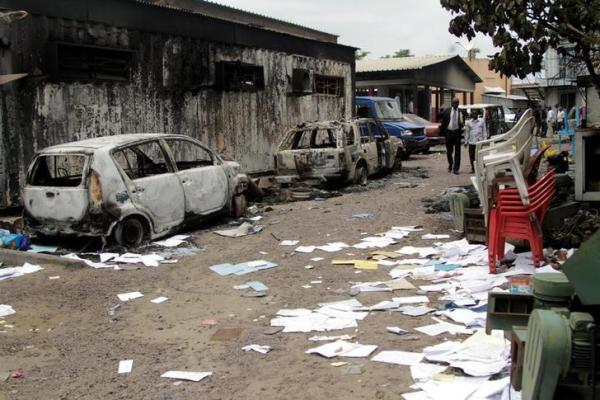 Congolese civilians walk past a house and vehicles which were burnt during anti-government protests to press President Joseph Kabila to step down in the Democratic Republic of Congo's capital Kinshasa, September 21, 2016.