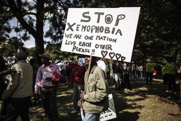 A demonstrator holds a banner through in Johannesburg on April 23, 2015 during a march gathering several thousands of people to protest against the recent wave of xenophobic attacks in South Africa. Nigeria says over dozens of its citizens have been killed in xenophobic attacks in South Africa in the last two years.