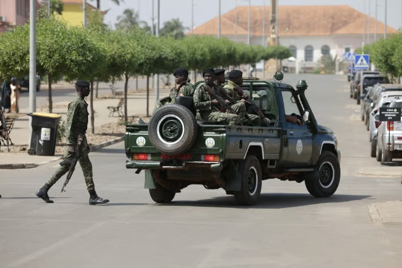 Armed soldiers patrol a street near the presidential palace in Bissau where shots were fired on November 26, 2025.