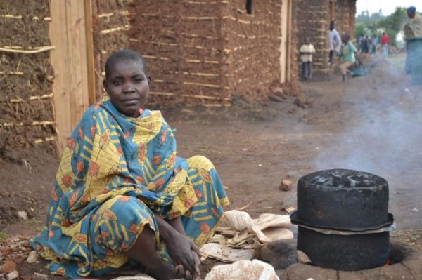 A woman prepares food outside her new semi-permanent home in Mahama refugee camp