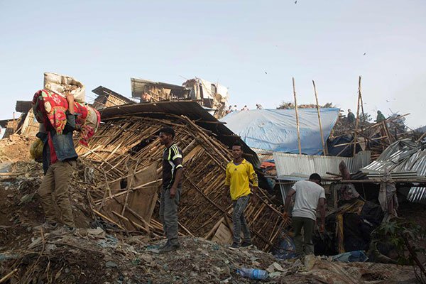 People move their belongings after dwellings built near the main landfill of Addis Ababa on the outskirts of the city were damaged in a landslide on march 12, 2017.
