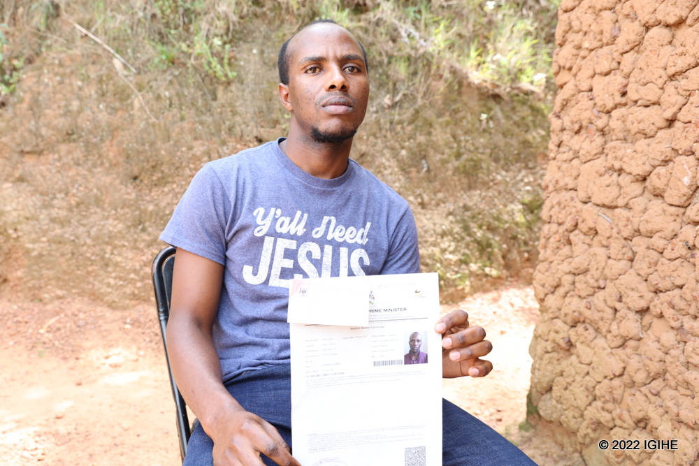 Shyaka showing documents granting him refugee status issued by Uganda's Office of the Prime Minister.  