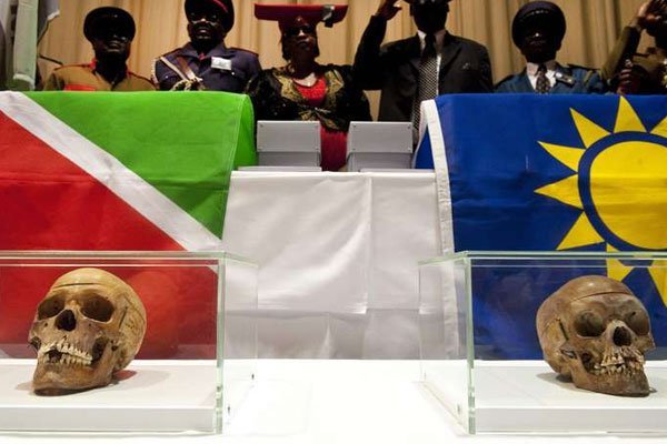 Members of a Namibian delegation stand behind two following a hand-over ceremony of 20 skulls taken from Namibia, in the Charite Hospital on September 30, 2011.