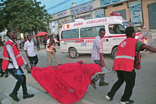 People carry the body of a victim from the site of car bomb attack in Mogadishu on May 8, 2017.