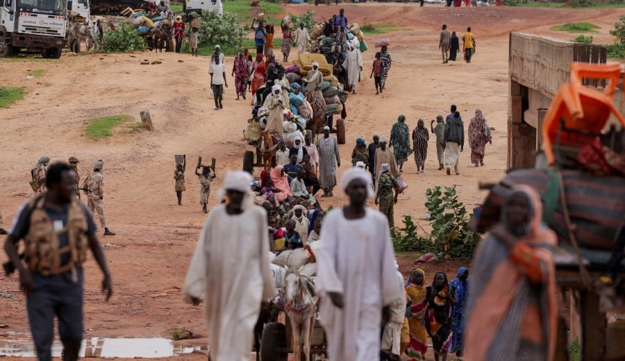 Sudanese people, who fled the conflict in Murnei in Sudan’s Darfur region, cross the border between Sudan and Chad in Adre, Chad August 4, 2023