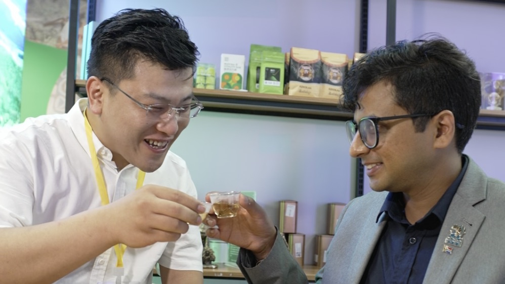 Tea vendor Wang Mingjie [left] describes how his family has sold Chinese tea for generations, from Fujian to the world.