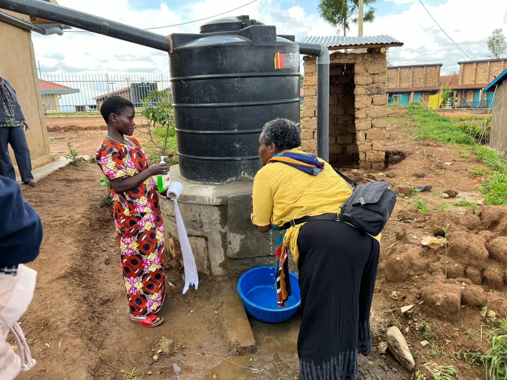 Towari Marie Louise washing hands using water from one of water tanks given to historically marginalized people in Gicumbi.