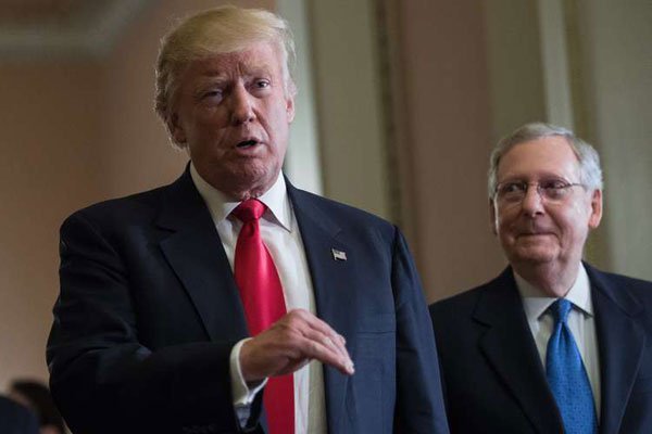US President-elect Donald Trump speaks to the press with Senate Majority Leader Mitch McConnell (right) following a meeting at the Capitol in Washington, DC, on November 10, 2016.