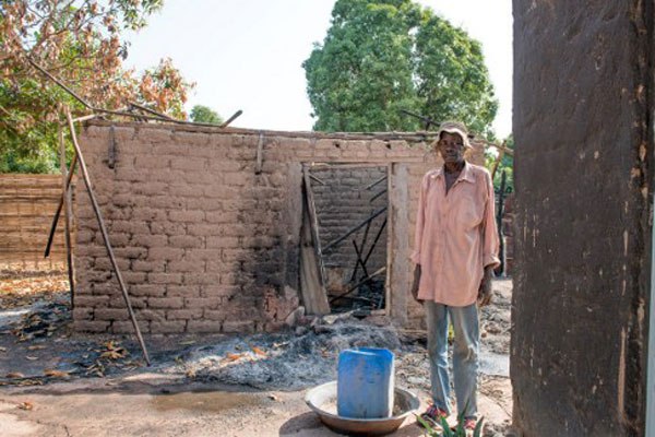 A man searches for belongings to salvage in a burned down house in Nazareth, on the outskirts of Wau, on July 3, 2016 after fighting in Wau displaced thousands of civilians.