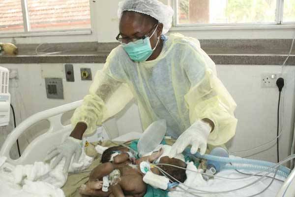A nurse at Coast Provincial General Hospital attends to the conjoined twins born on Thursday morning. The twins died early Sunday before they could be flown to Nairobi for specialised treatment.