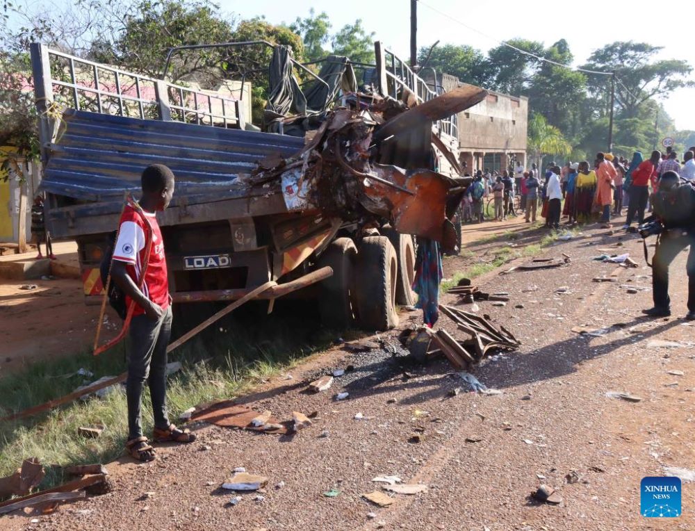 People look at the wreckage of a bus along the Kampala-Gulu highway in Uganda, Jan. 6, 2023.
