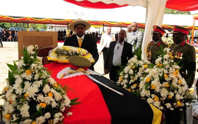 Uganda’s president lays a wreath of flowers on the casket of the late General Aronda Nyakairima.