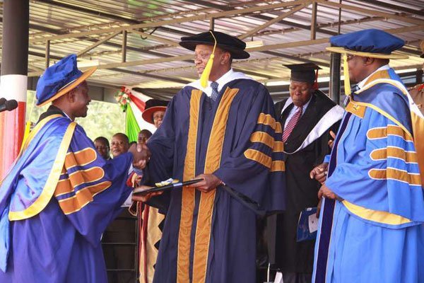 President Uhuru Kenyatta (centre), confers a doctorate to Daniel Otunga Ananda (left) at Kibabii University's graduation in Bungoma on November 24, 2016.