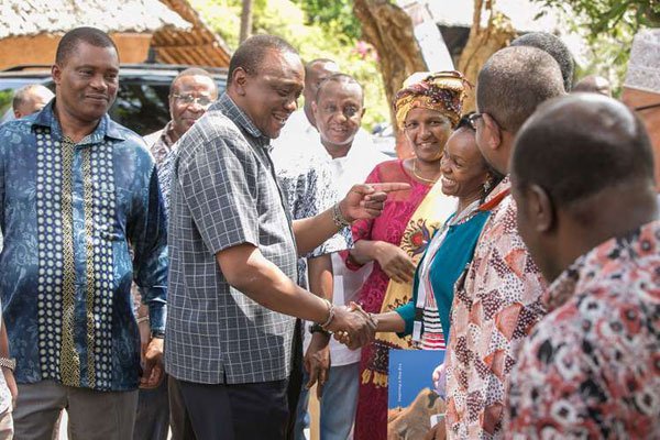President Uhuru Kenyatta shares a light moment with the Kenya Private Sector Alliance CEO Carole Kariuki during the second National Leadership Summit at Leisure Lodge Beach and Golf Resort in Kwale County, on November 3, 2016.