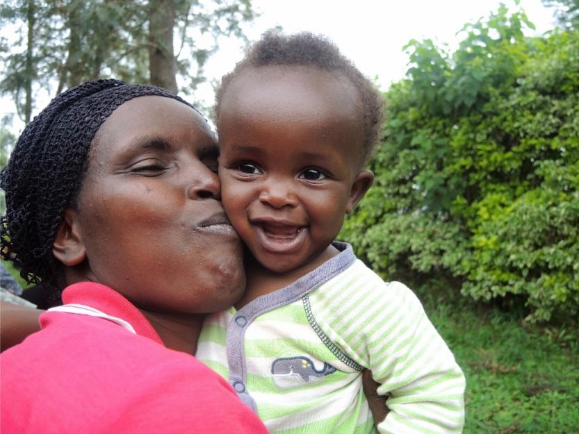 A woman plays with her neighbor's baby during the Umuganda community meeting in Kigali, Rwanda. (GSR photo / Melanie Lidman)