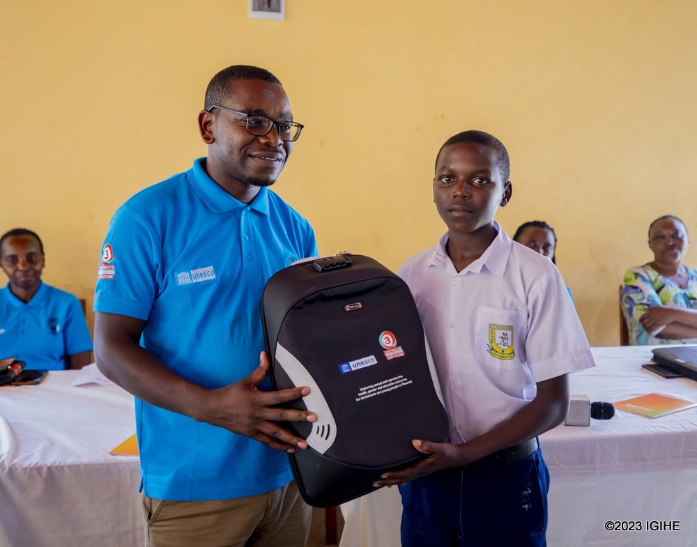 Dr Mpozembizi handing over a prize to a student who gave a correct answer. 