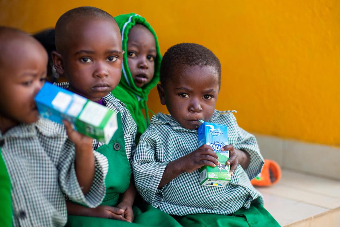 David sips his milk box during morning break at his day care centre on the Rutsiro Tea Plantation.
