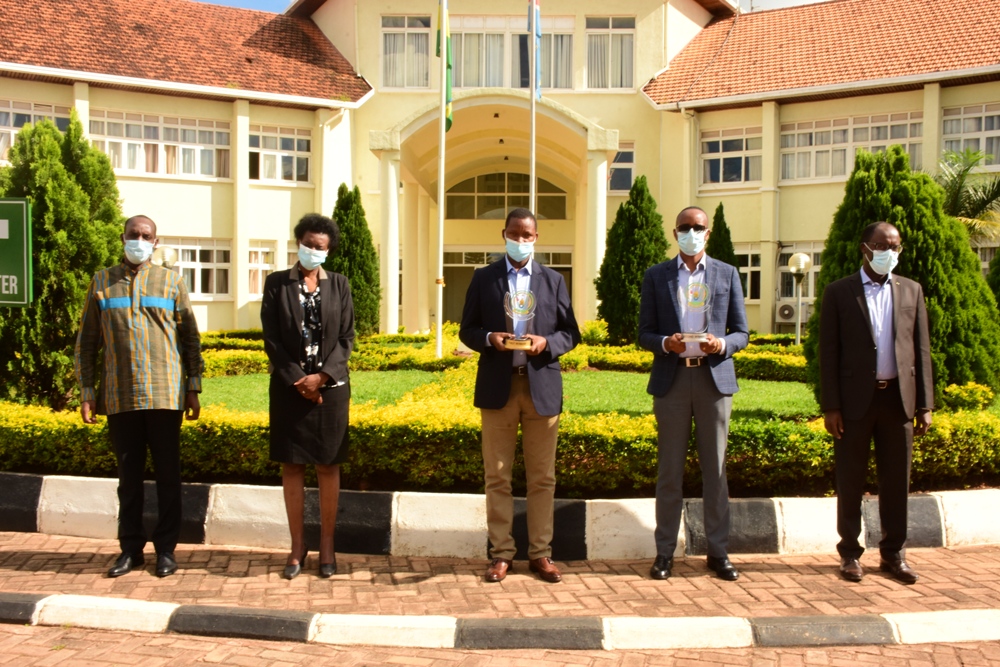 The mayor of Kirehe and Bugesera district (in the middle) holding trophies for the best performance.   