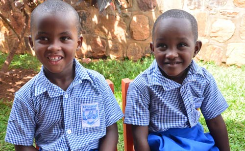 Keza (right) with her classmate Wilson (left) discussing their future goals.