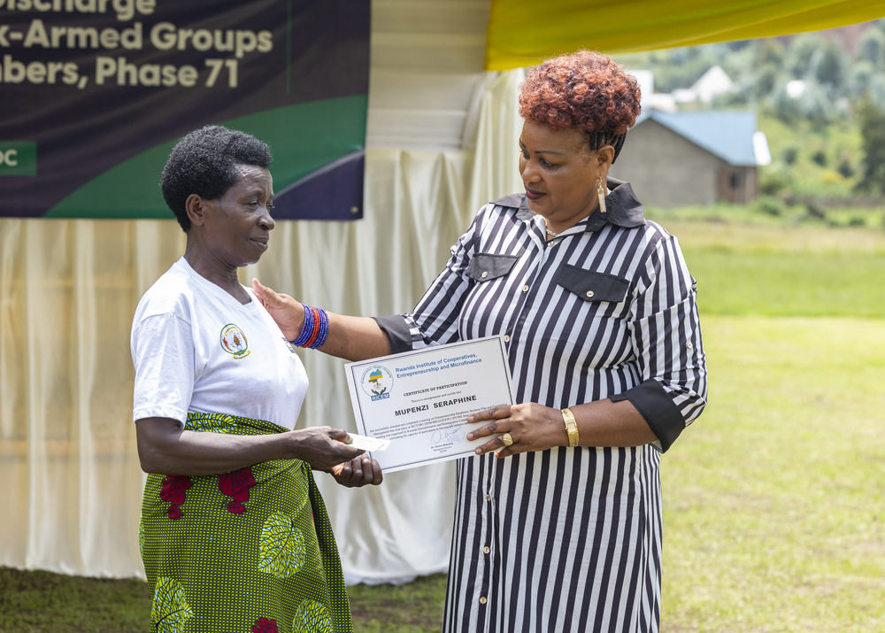 The demobilized mother (left) receiving certificate from Nyirahabineza, held the rank of corporal in FDLR.