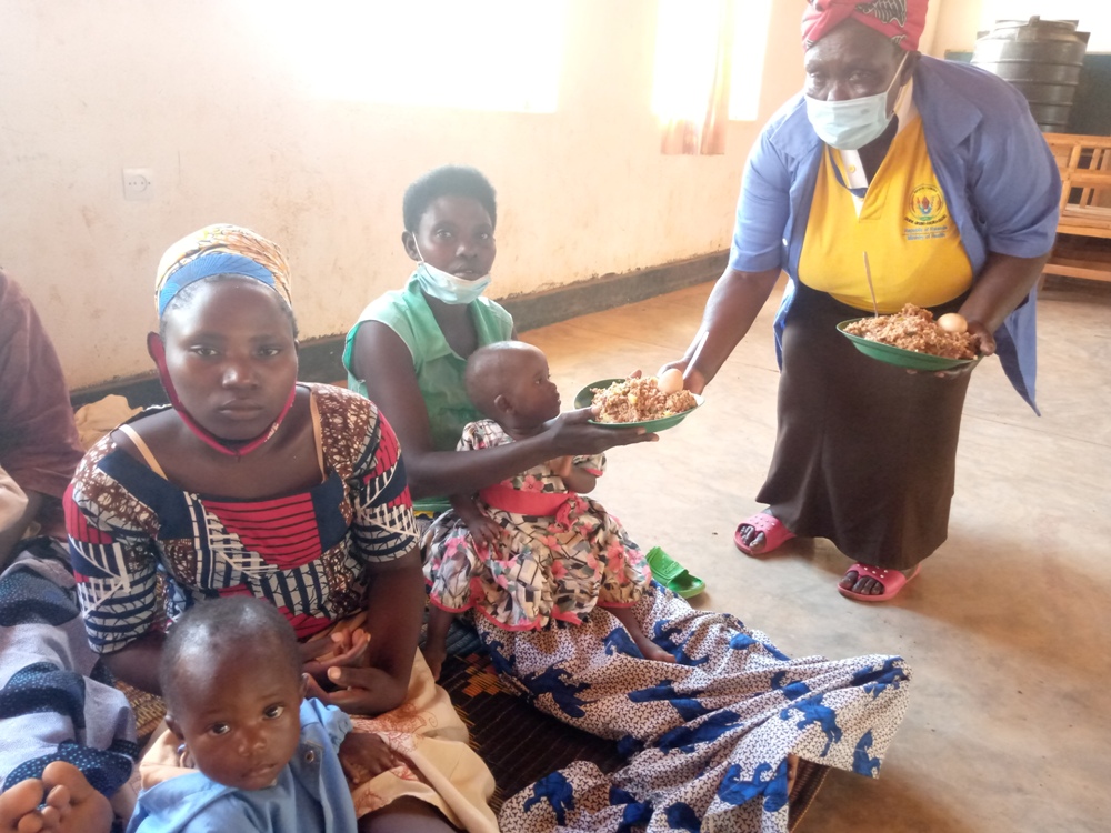 A community health worker serving food after cooking demonstrations.
