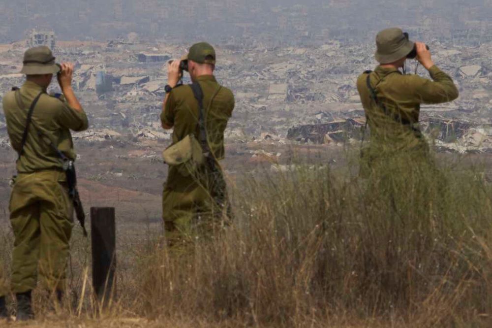 Israeli soldiers uses binoculars to look at damaged buildings in the Gaza Strip, from southern Israel, Wednesday, Aug. 13, 2025.  Photo Ariel Schalit/AP