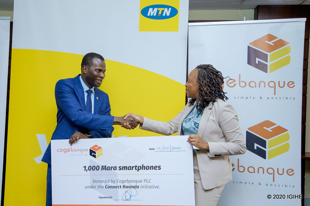Cogebanque CEO Cherno Gaye presents MTN CEO Mitwa Kaemba Ng'ambi with cash check