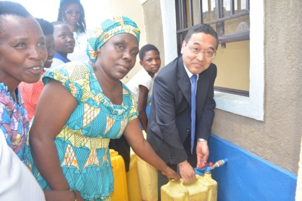 Ambassador Takayuki (R) and Uwiragiye inaugurate water kiosk
