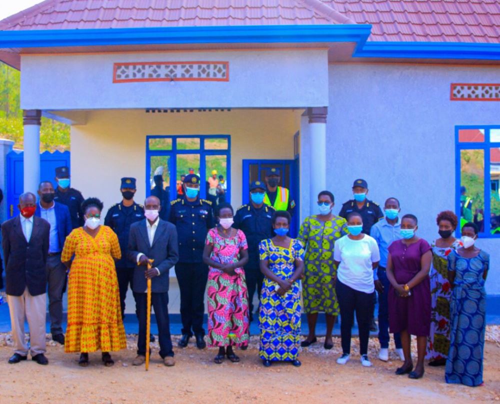 Police officers in a group photo with beneficiaries and Kamonyi district officials and handing over the house.
